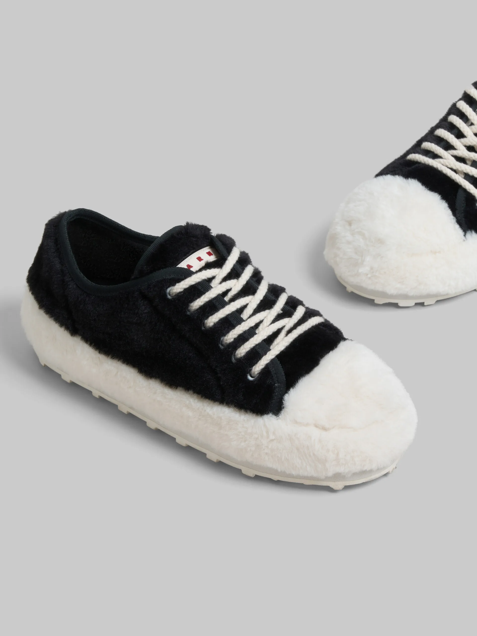 Zapatilla de tenis negra de peluche